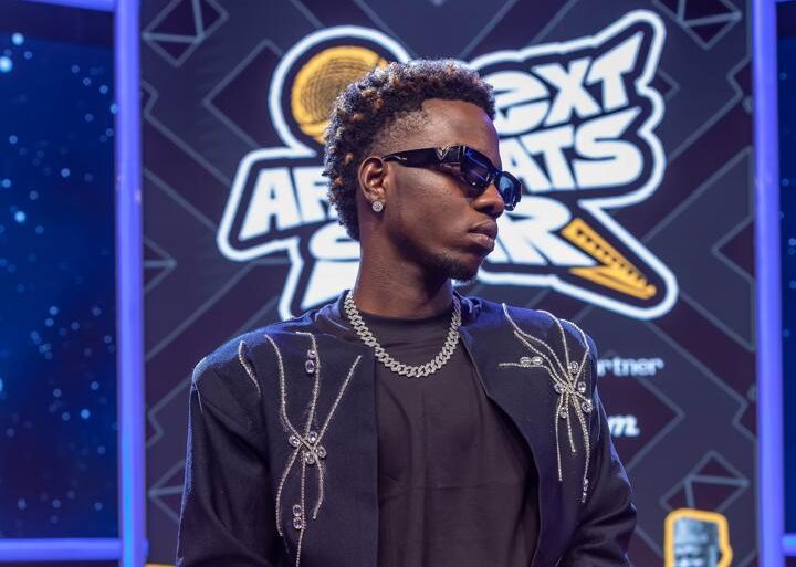 A focused Afrobeats artist overcoming audition rejection in a Lagos studio setting