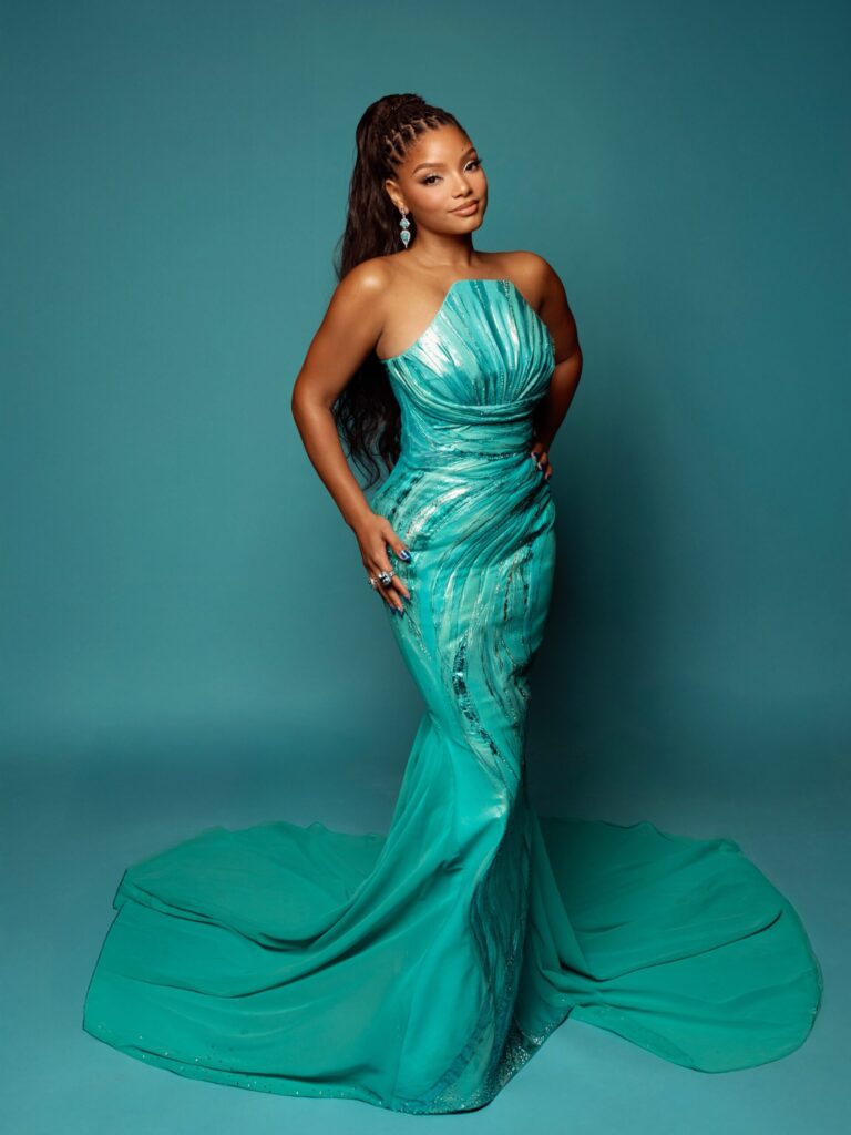 A teal mermaid gown with intricate shell detailing, representing Halle Bailey's premiere look.