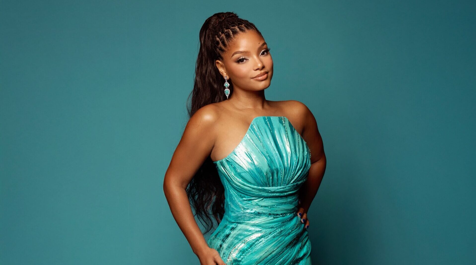A teal mermaid gown with intricate shell detailing, representing Halle Bailey's premiere look.