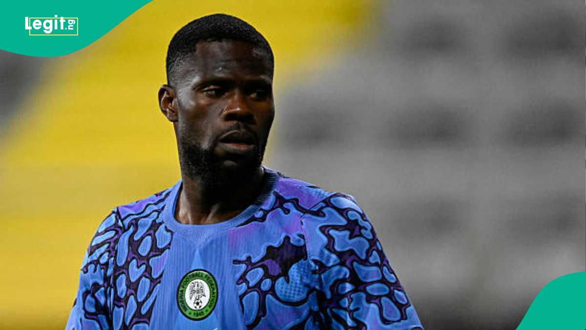 Nigerian goalkeeper Francis Uzoho in action during a Super Eagles match, diving to make a crucial save in a packed stadium.