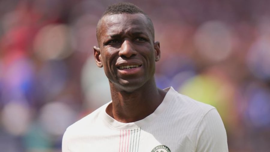 A Nigerian Chelsea fan watches a Premier League transfer announcement featuring Aston Villa's interest in Nicolas Jackson, symbolising the African football community's engagement with European transfers.