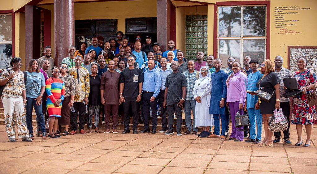 Lecturers and students in a university lecture hall collaborating with laptops and tablets, representing AI skills training in Nigerian higher education.