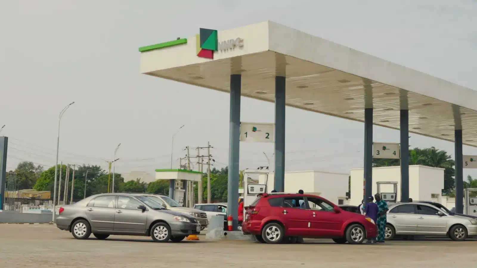 A Nigerian petrol station at dusk with cars refueling, symbolizing rising fuel prices and economic impact