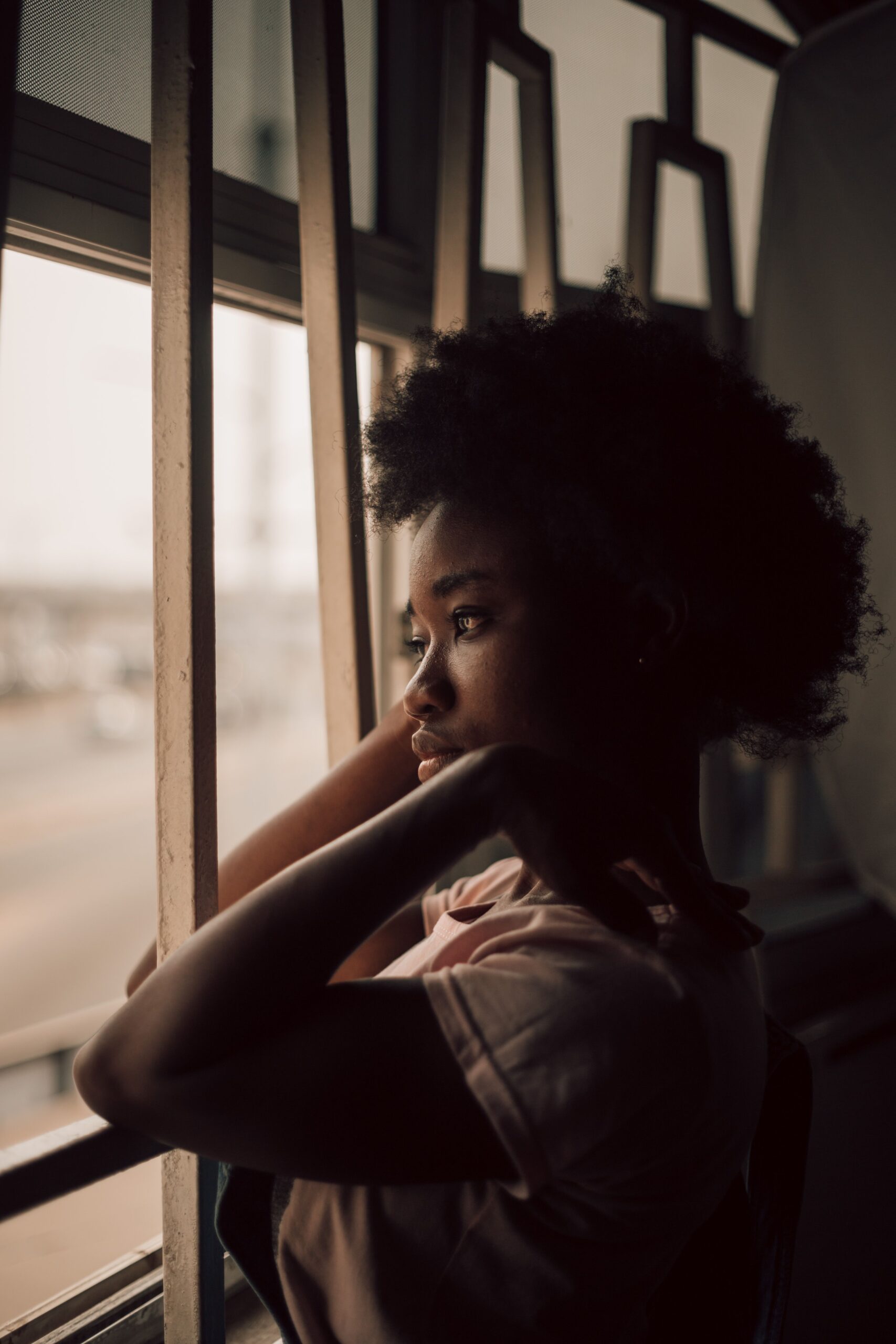 A young woman reflecting on life at 18 while reading a book in a Lagos home setting