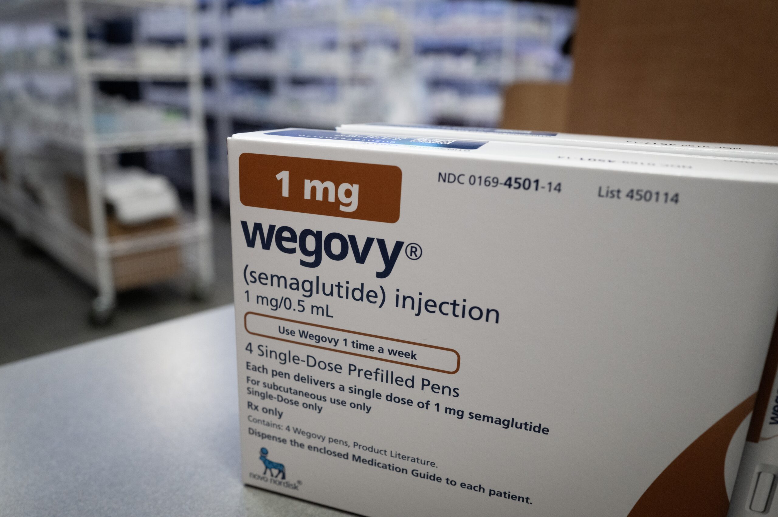 A well-lit pharmacy counter with shelves of prescription medications, representing access to healthcare services.