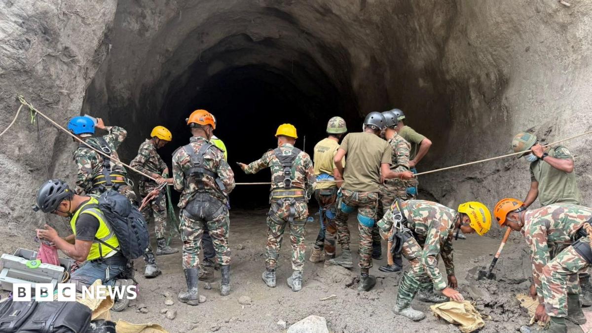 Rescue workers in protective gear detonate controlled explosives to clear a landslide blocking access to a damaged hydropower site in Nepal, 2026.