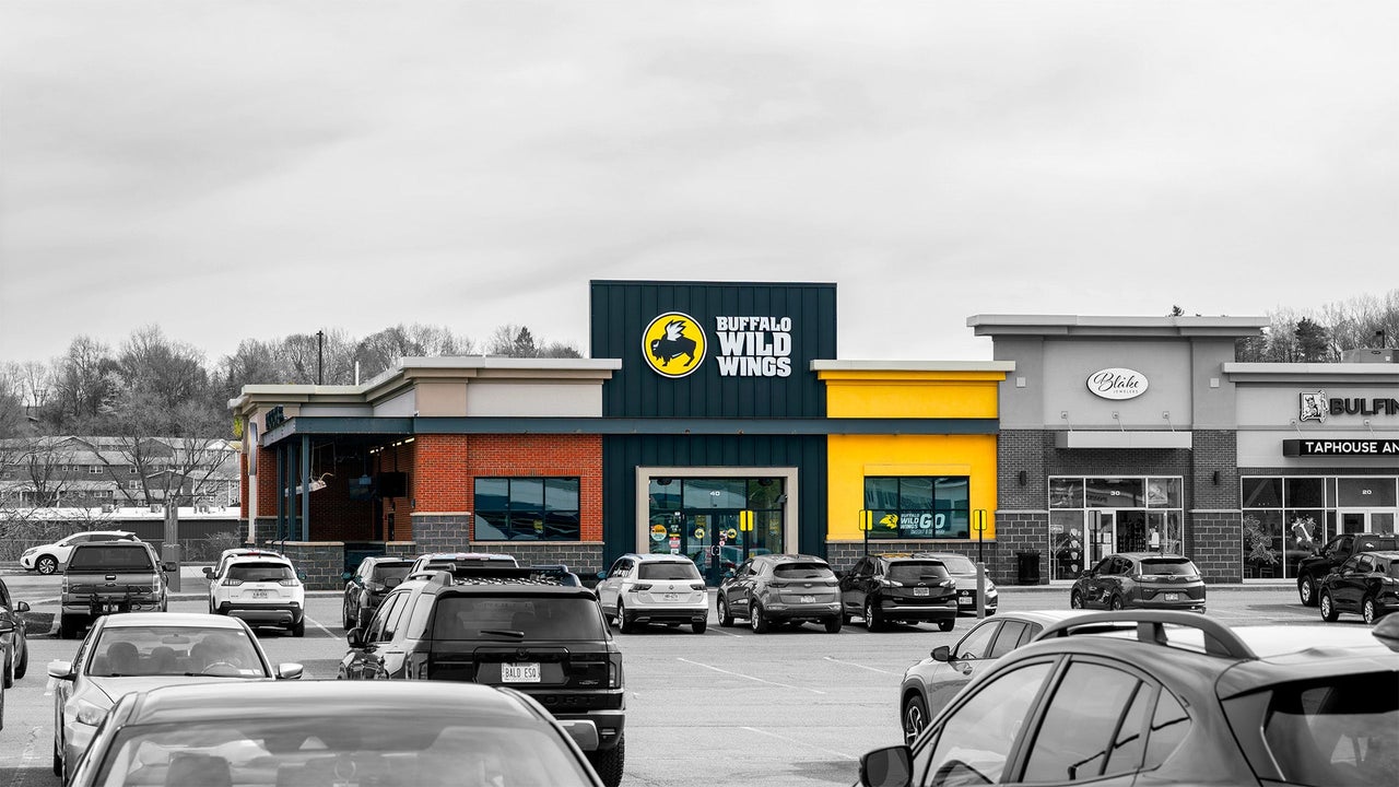 Interior of an empty Buffalo Wild Wings restaurant showing a quiet sports bar setting with no people present.