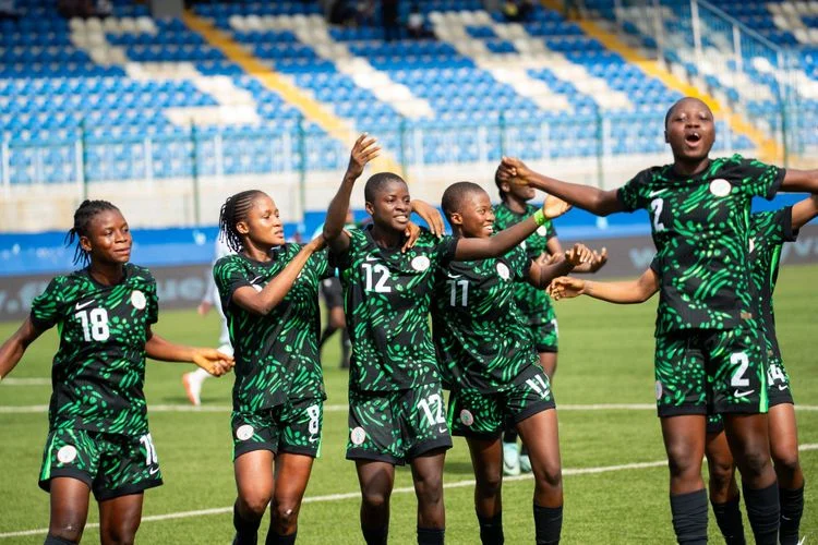 Nigerian U‑17 women’s team celebrating victory with the WAFU trophy on the pitch