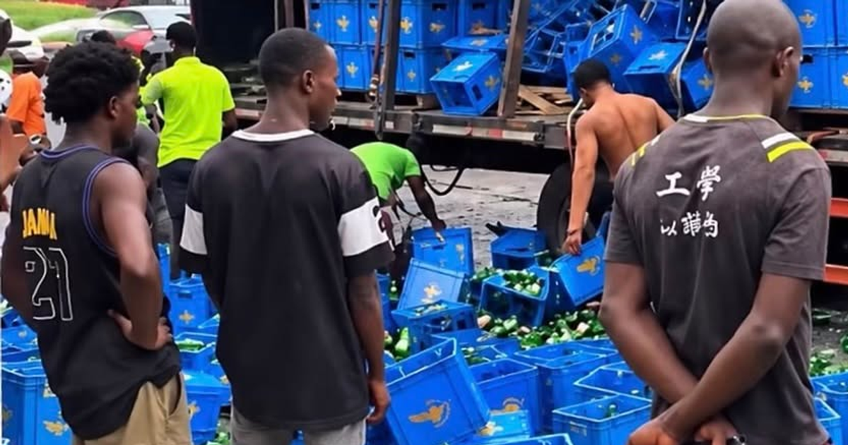 Crowd gathered around an overturned van with spilled beer bottles on a Lagos road