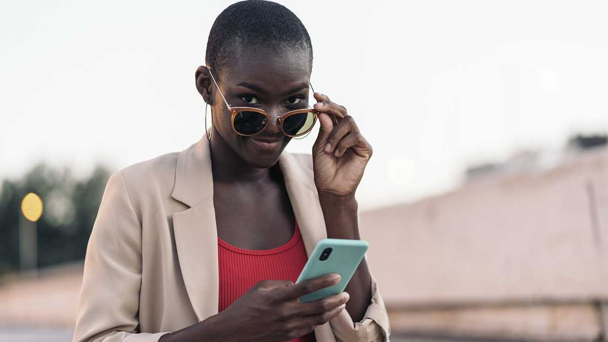 African woman contemplating her reflection in a bathroom mirror, symbolizing self-reflection after personal transformation