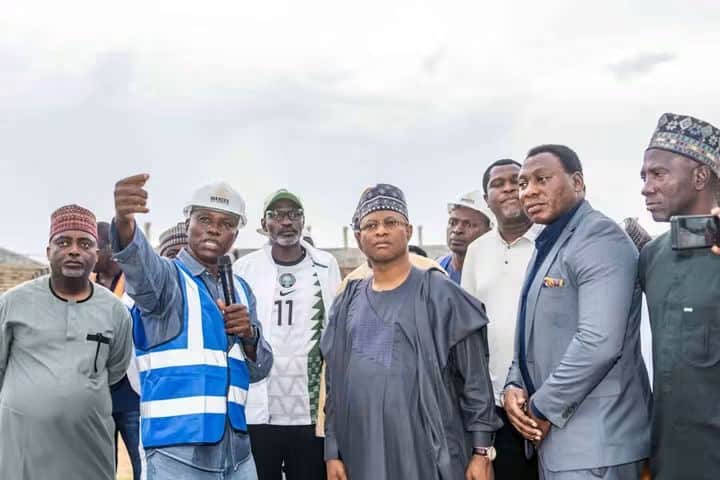A symbolic representation of Kaduna State’s recognition of Nigeria’s Atlanta 1996 Olympic football heroes, featuring a stadium setting with plaques bearing their names and the Nigerian flag.