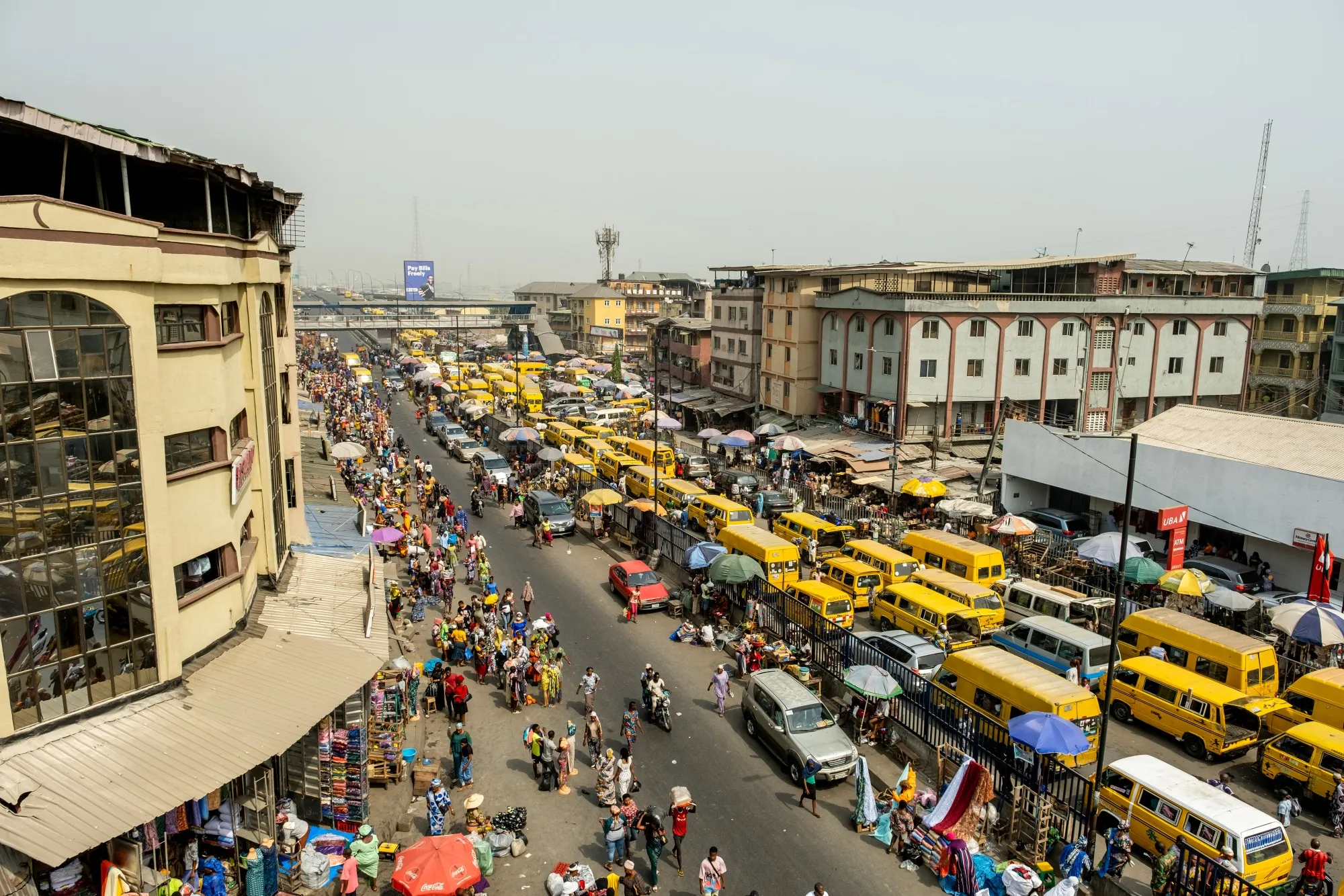 A Lagos street at dusk with rising revenue graphs subtly overlaid, symbolising MTN Nigeria's increasing total income but declining revenue per user.