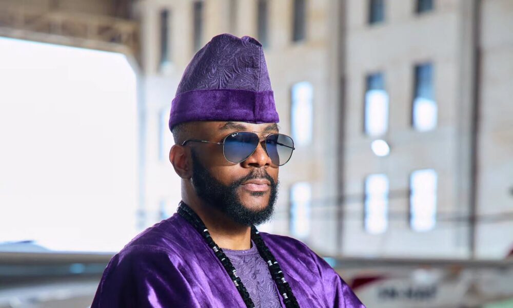 Regal purple D29 Africa agbada with gold embroidery displayed on a runway