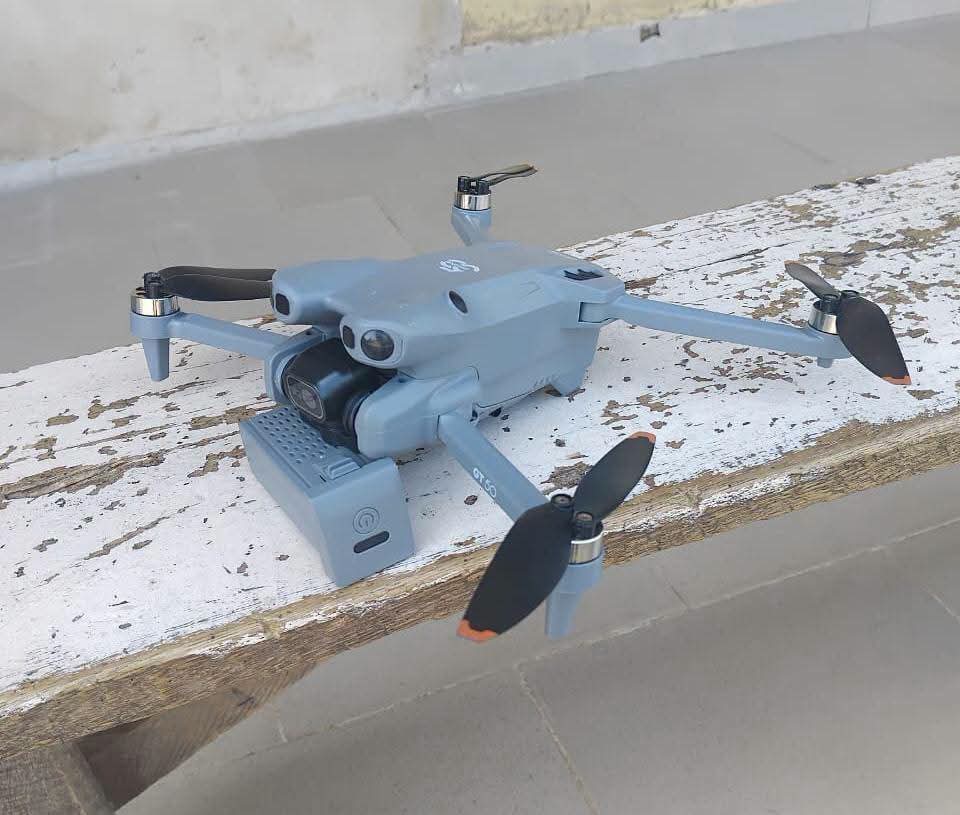 Police vehicles and a recovered drone near Kano State Police Command at night