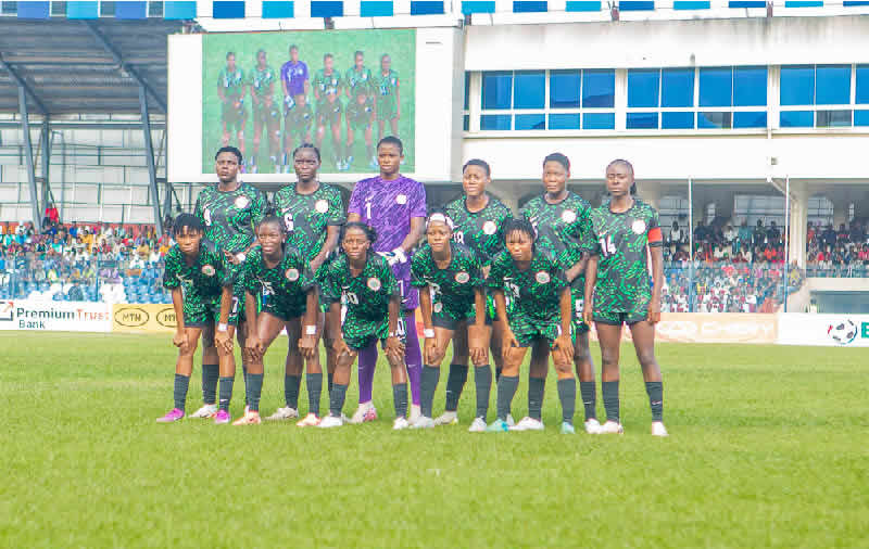 Nigerian U-20 women's football team celebrating a 10-1 victory over New Caledonia on a sunny outdoor pitch