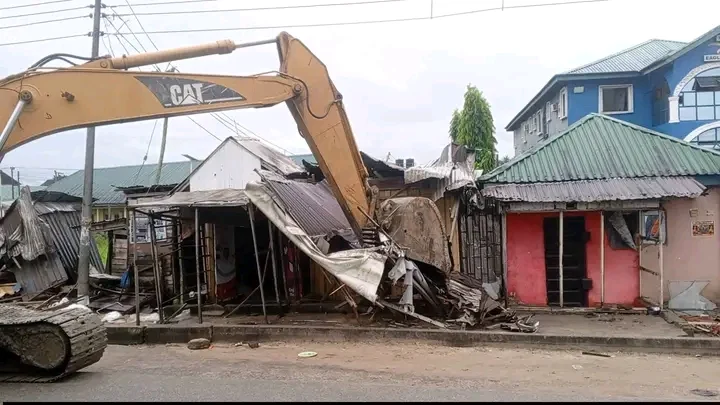 Demolished illegal structure on a road in a Nigerian city, showing restored roadway width