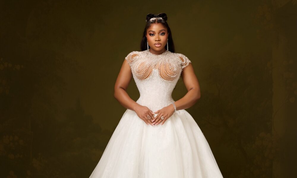 A bespoke white ballgown with a structured basque corset and crystal-beaded sheer yoke, designed by Veekee James.