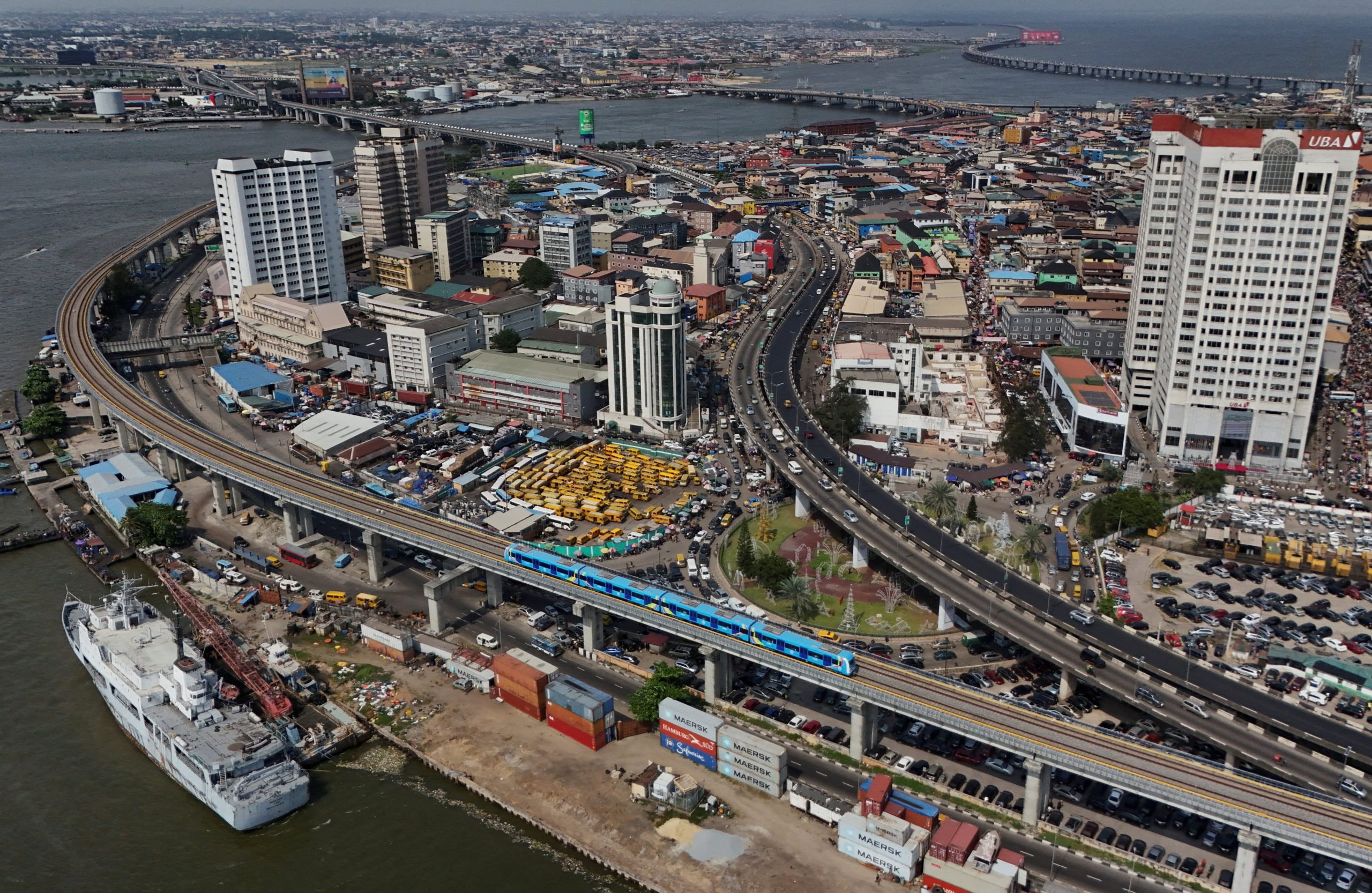 Lagos traffic at sunset showing danfo buses, cars, okadas and keke tricycles on a busy highway