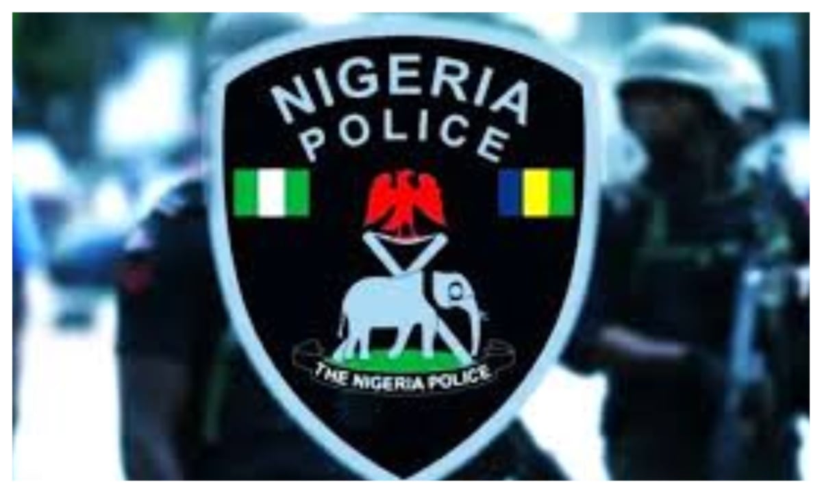 Nigerian police officer near a public bus on a Lagos street at evening
