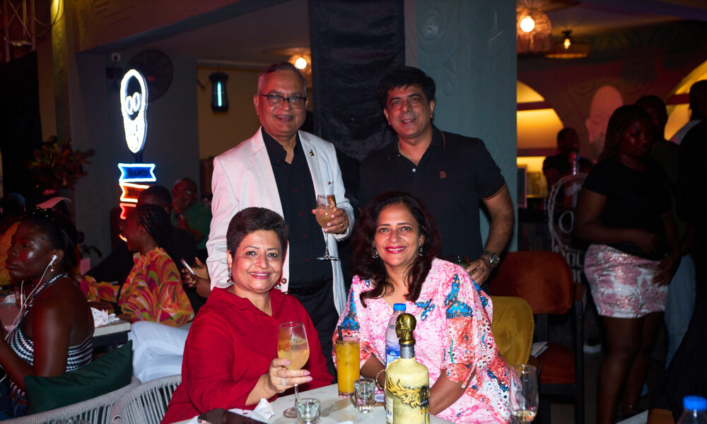 Lagos nightlife bar scene with tequila bottles and patrons enjoying cocktails under string lights
