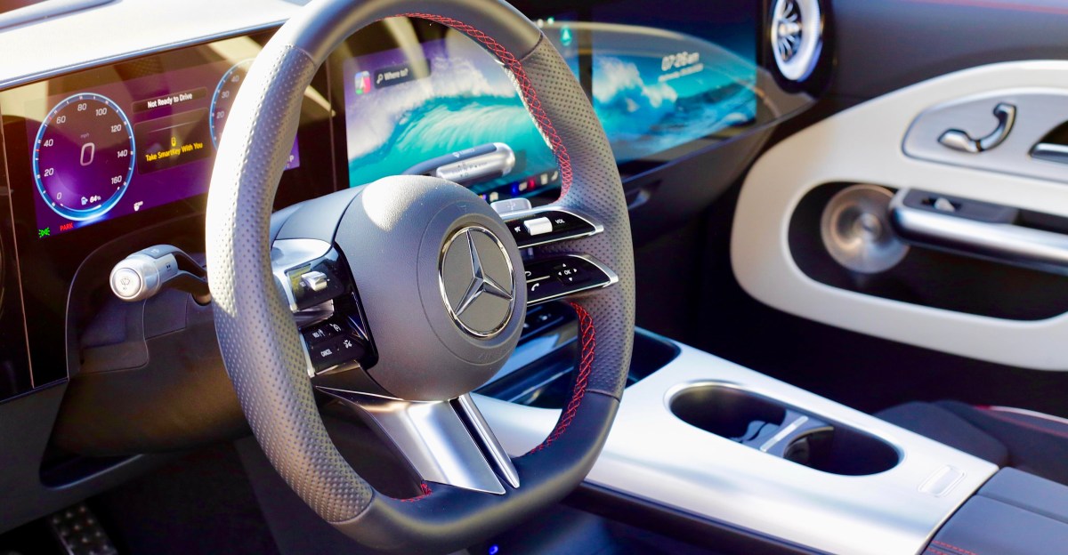 A modern car dashboard at night, showing subtle blue ambient lighting and minimal tech interfaces, representing seamless in-car technology.