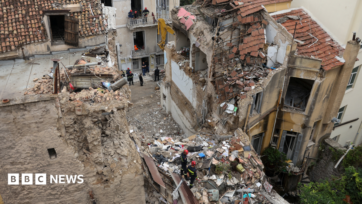 Aftermath of the Athens building explosion near the Acropolis, showing smoke and emergency response.