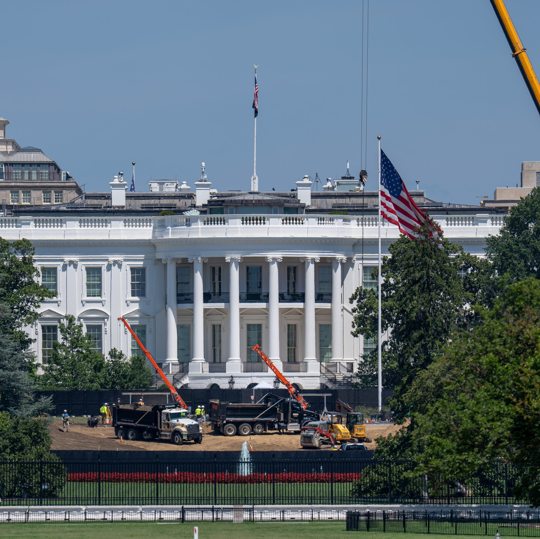 Construction activity around historic Washington DC buildings with cranes and scaffolding visible in the background of the capital cityscape