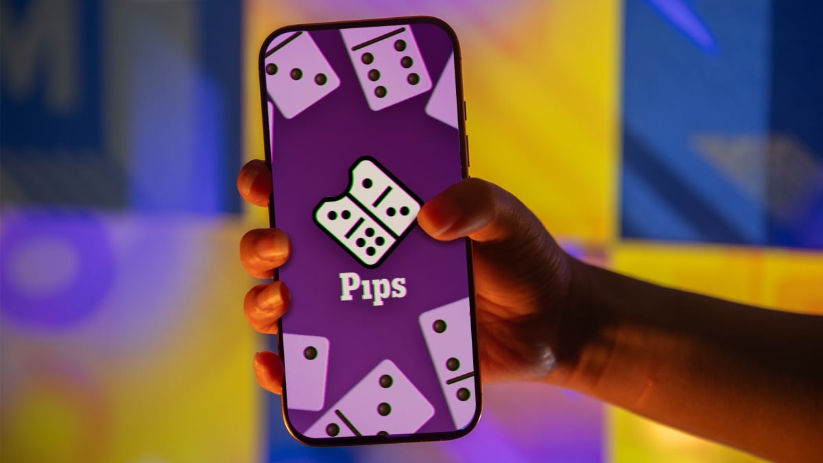 Colorful dominoes arranged in a grid on a wooden table with natural lighting