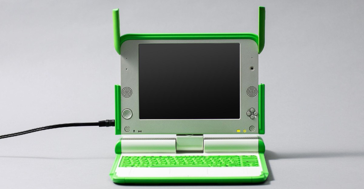 XO‑1 laptop on a desk with educational props, symbolizing the One Laptop Per Child project.