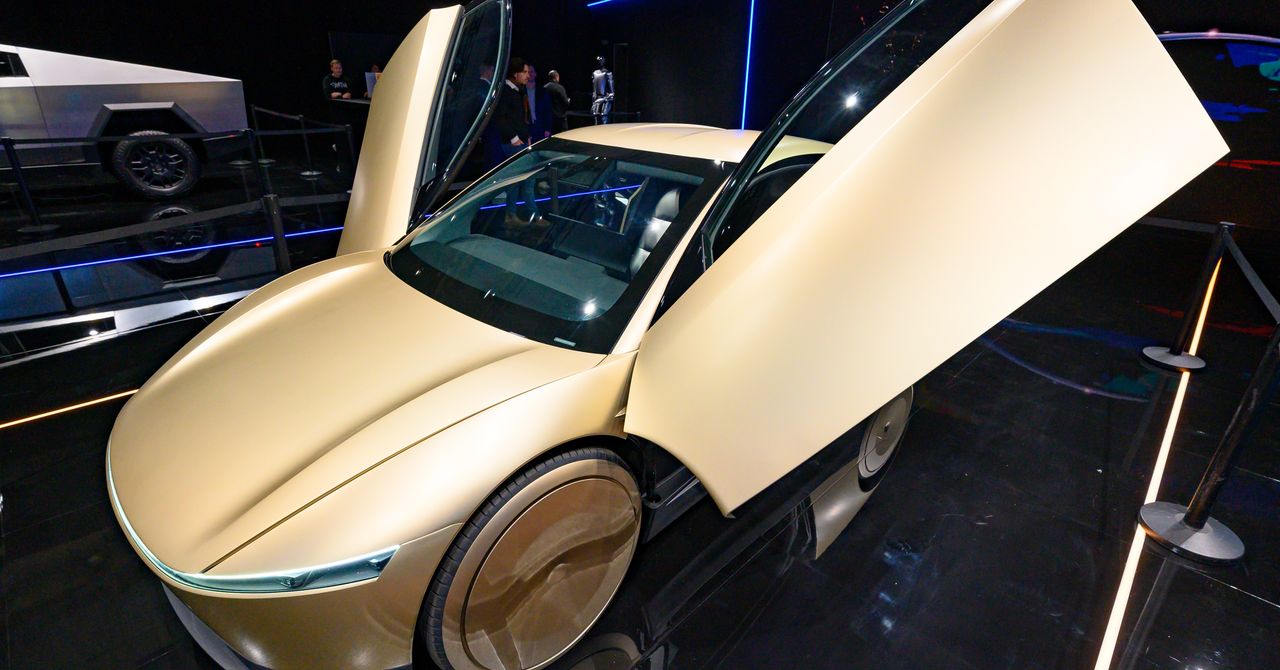 Tesla Cybercab autonomous vehicle on city street showing steering-wheel-free interior