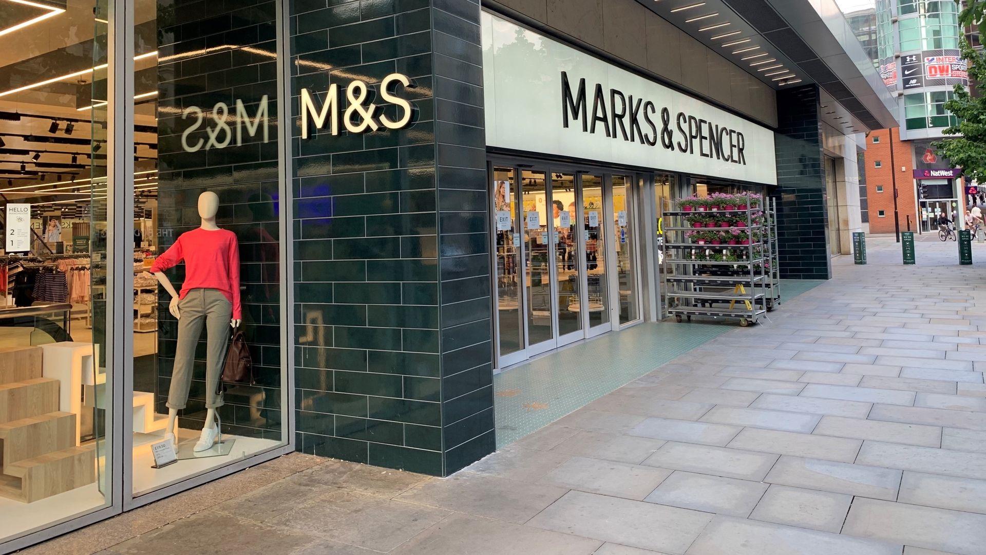Empty high street with M&S and Tesco storefronts under soft daylight, reflecting retail pressures in 2026