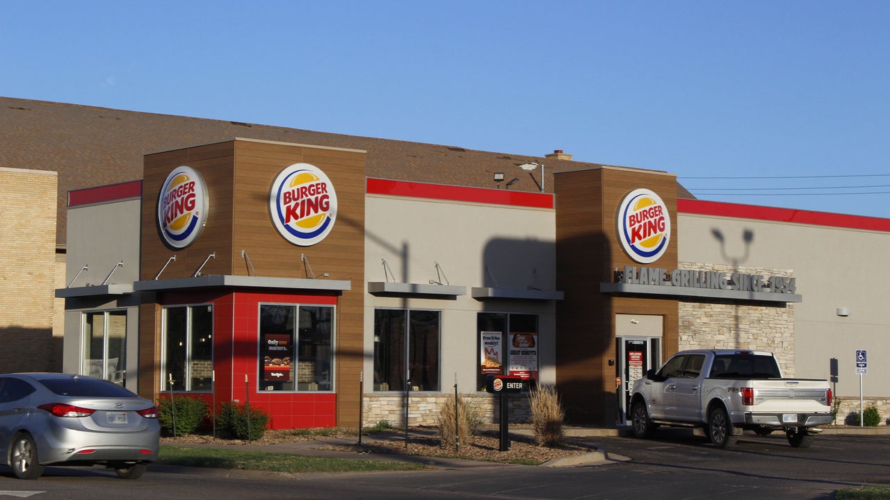 Closed Burger King restaurant with darkened sign and empty parking lot at dusk