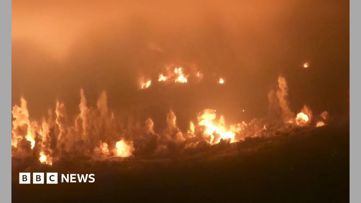 Mountainous terrain in southern Lebanon with smoke indicating a recent explosion.