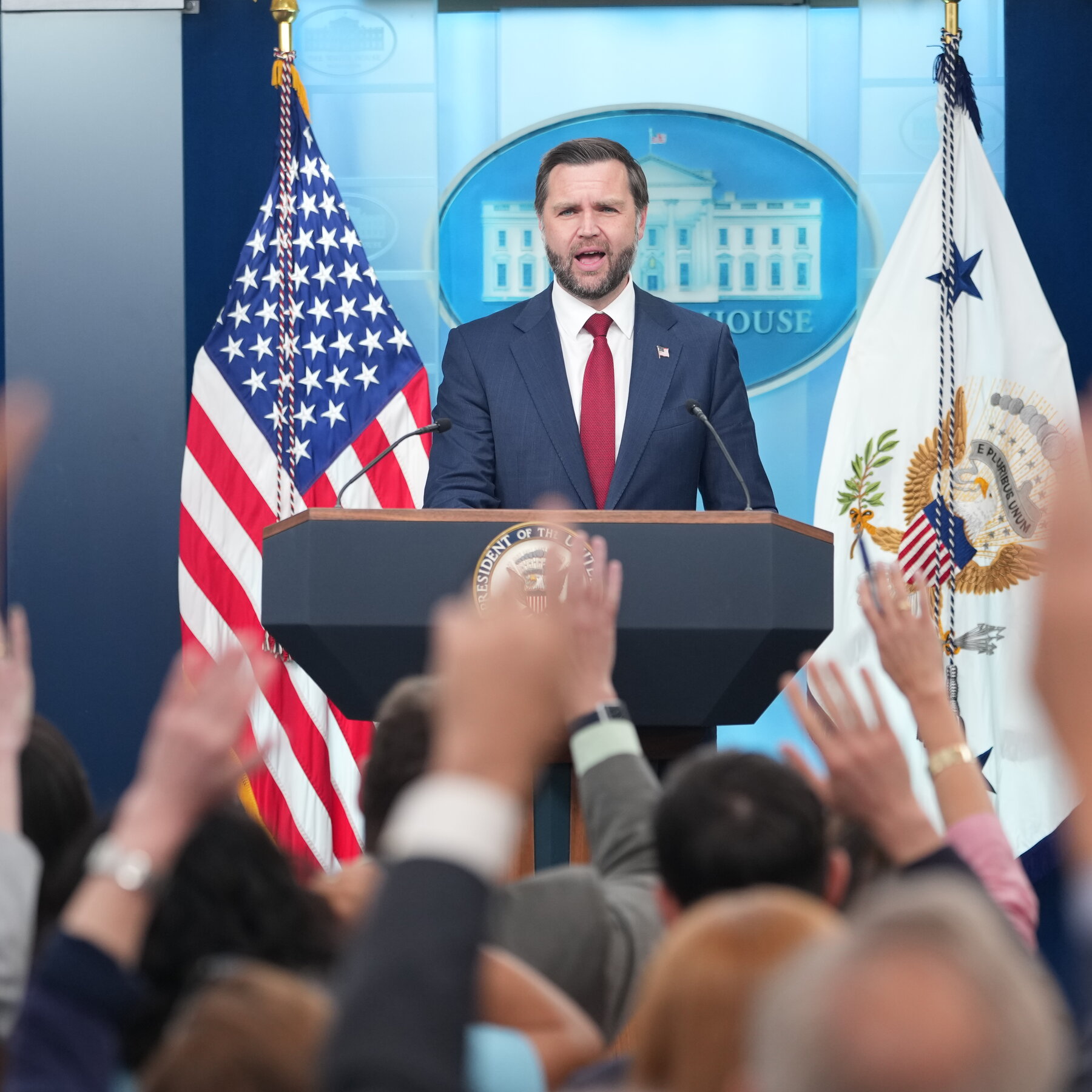 Empty White House press briefing table with microphone and glass of water, symbolizing diplomatic discussions on U.S.-Iran tensions.