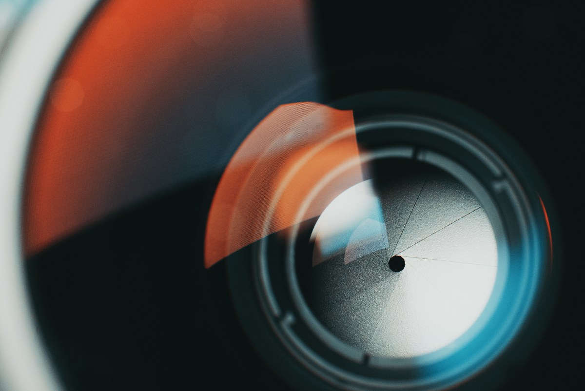 Smartphone camera module illuminated against a digital background