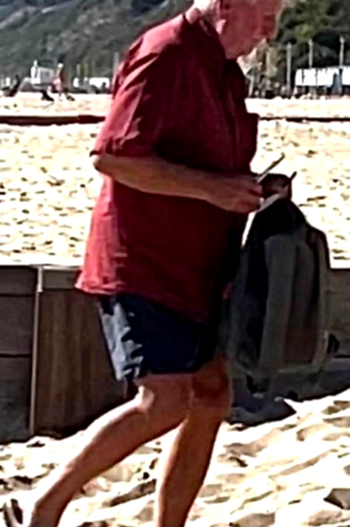 A generic beach scene with blurred figures and a somber atmosphere, symbolizing public controversy.