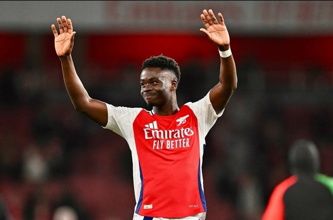 Arsenal supporters cheering with Lagos skyline in the background