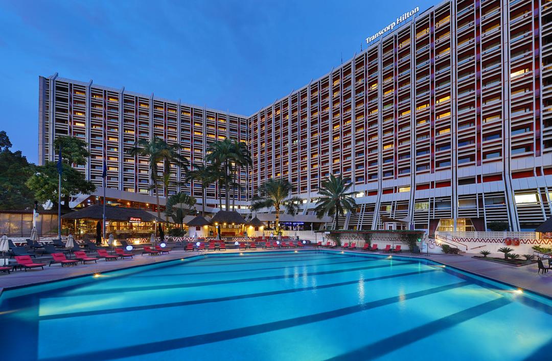Exterior of a contemporary Nigerian hotel illuminated at dusk
