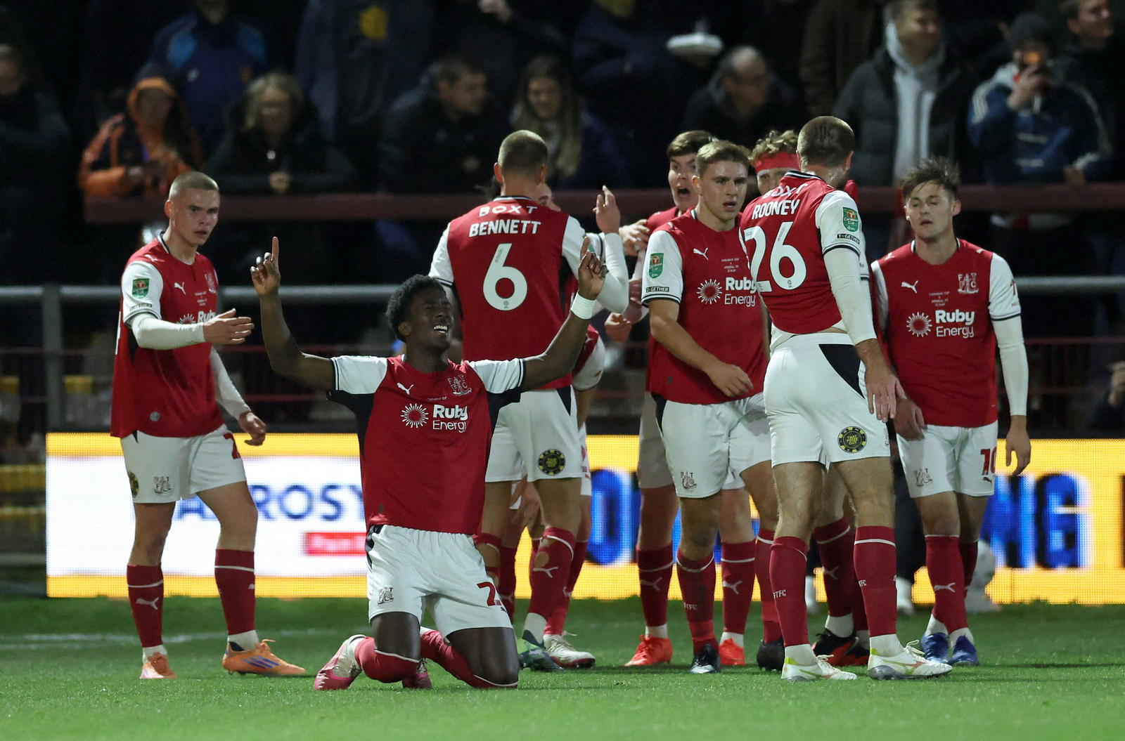 Football fans celebrating during a penalty shoot-out at a stadium