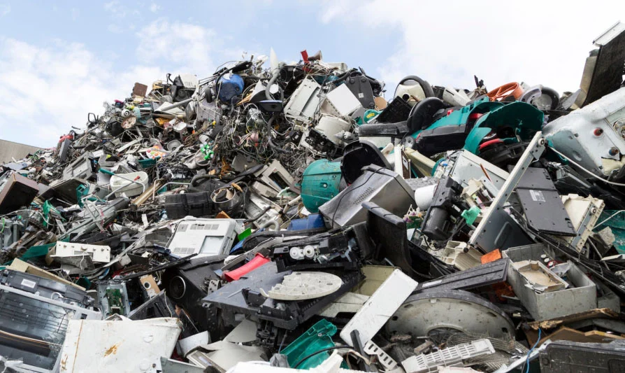 Workers sorting electronic components and circuit boards in a bright Nigerian workshop during e-waste recycling