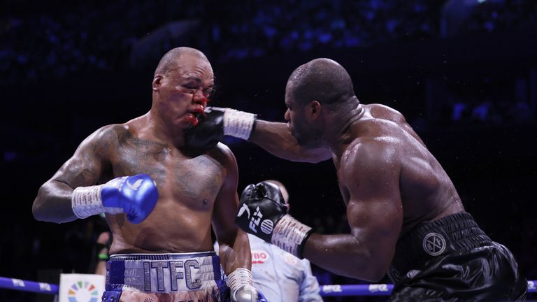 Boxing ring with two fighters in a high‑energy bout, African fans cheering in the background
