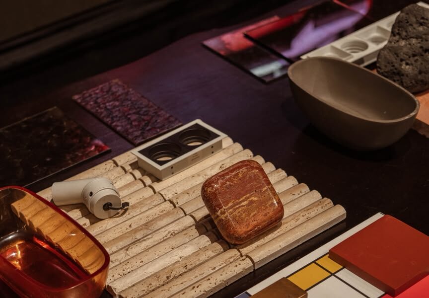 S.E.A CONSULTING's REDESIGN AFRICA installation at Design Week Lagos 2026 showing burgundy surfaces, raw tree bark, and Nigerian craftsmanship at the National Theatre