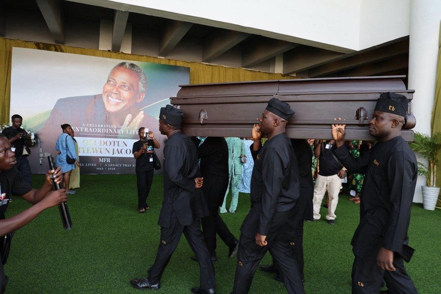 Mourners gathered at an outdoor funeral service in Lagos, Nigeria, under a decorative canopy