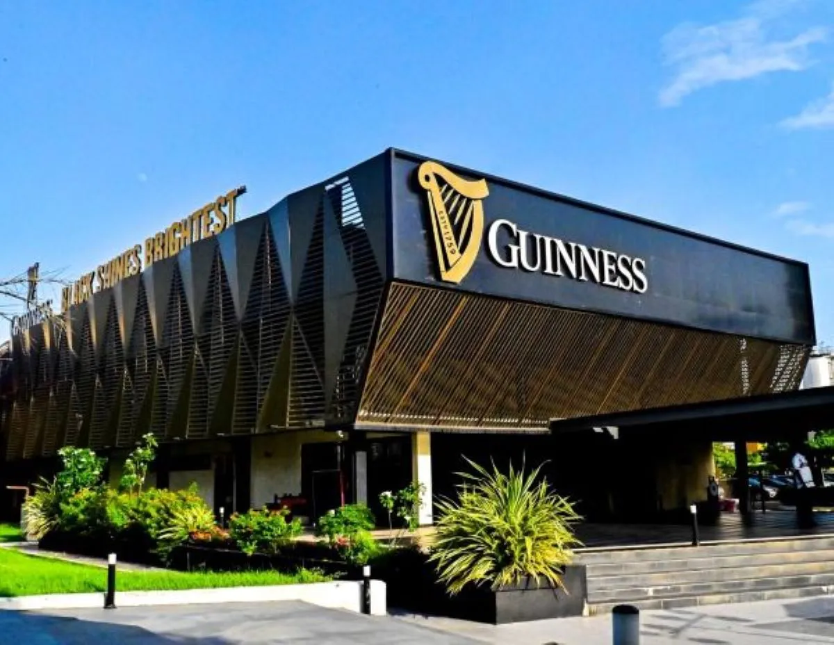 Guinness bottles displayed among Lagos market stalls at dusk, illustrating the brand’s local presence.