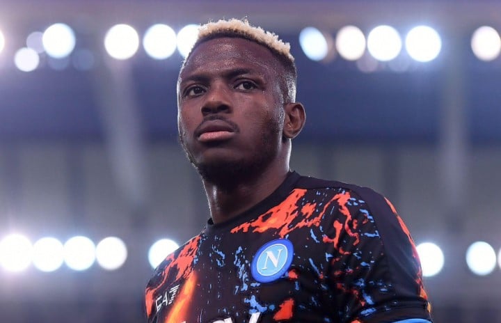 Nigerian football fans at a night match in a modern stadium