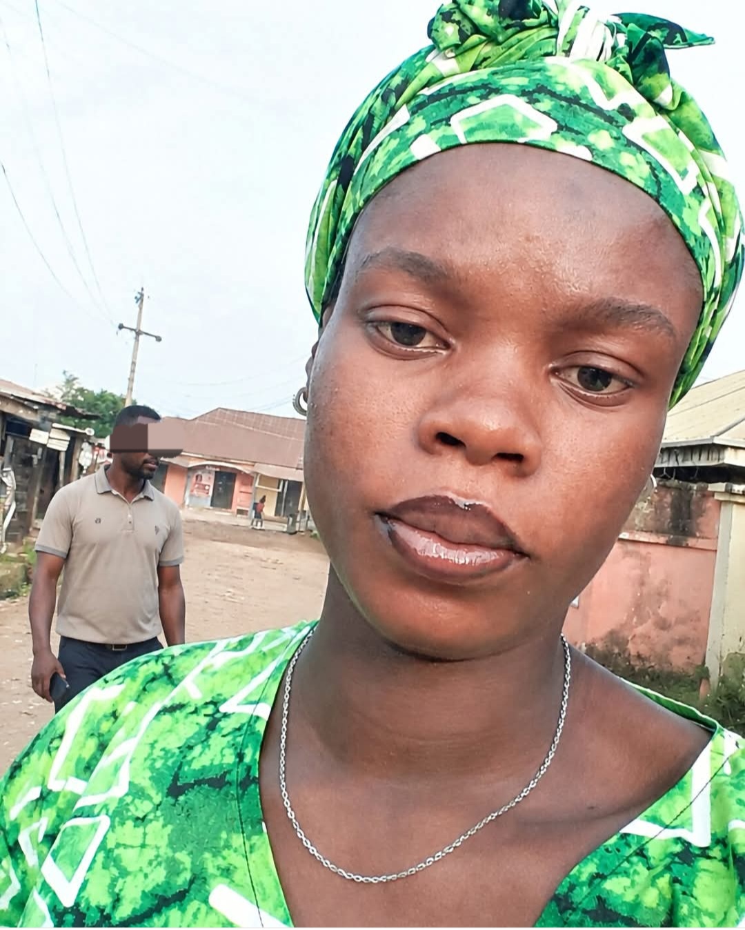 Pregnant woman walking through a lively Nigerian street market, symbolising vigilance and urban life.