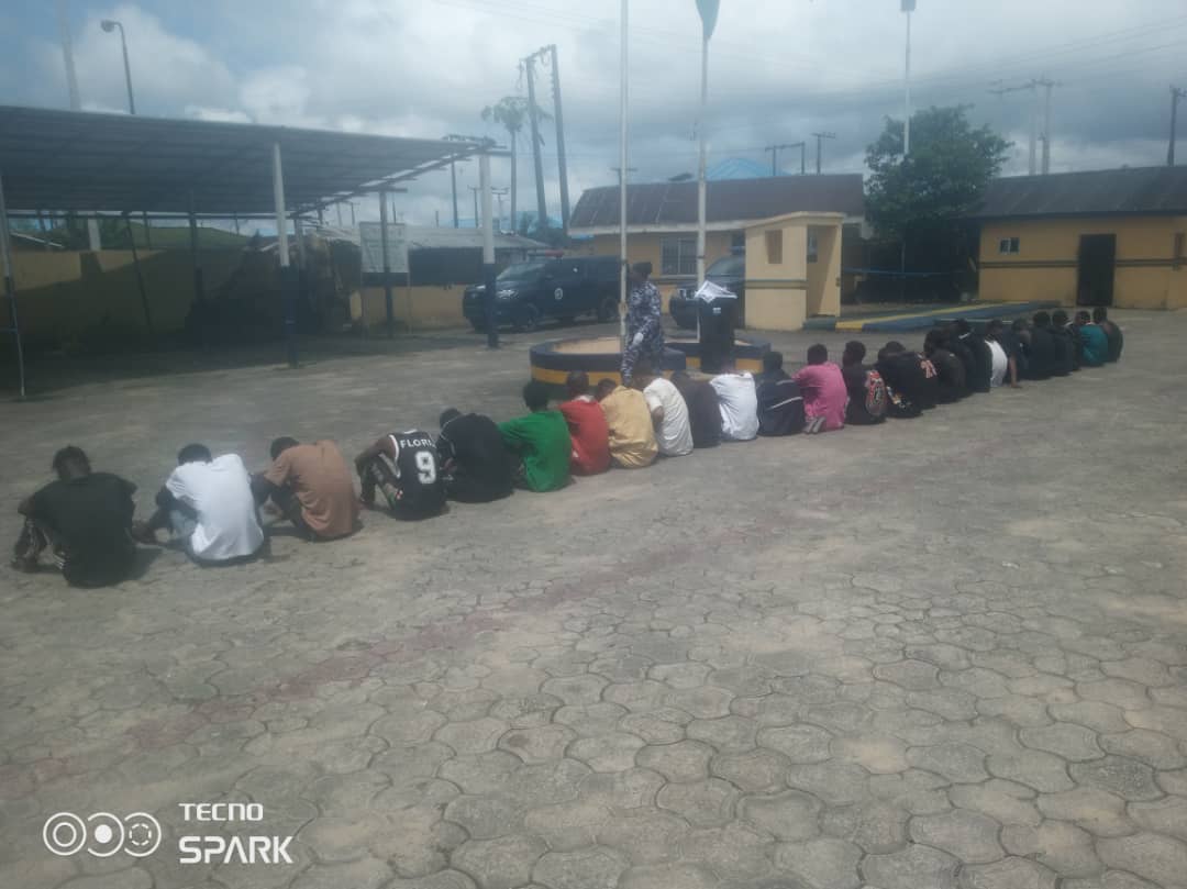 Police officers arranging seized firearms on a table during a security operation in a Nigerian town.
