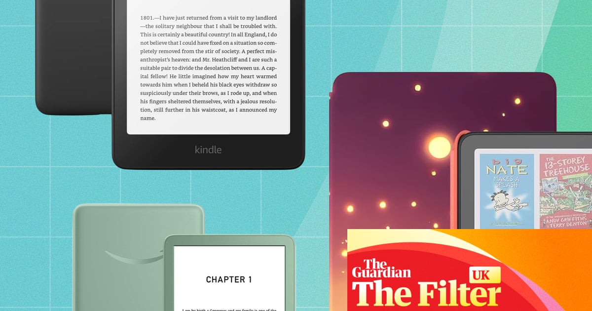Kindle e‑reader on a table beside a cup of tea in a cozy reading nook