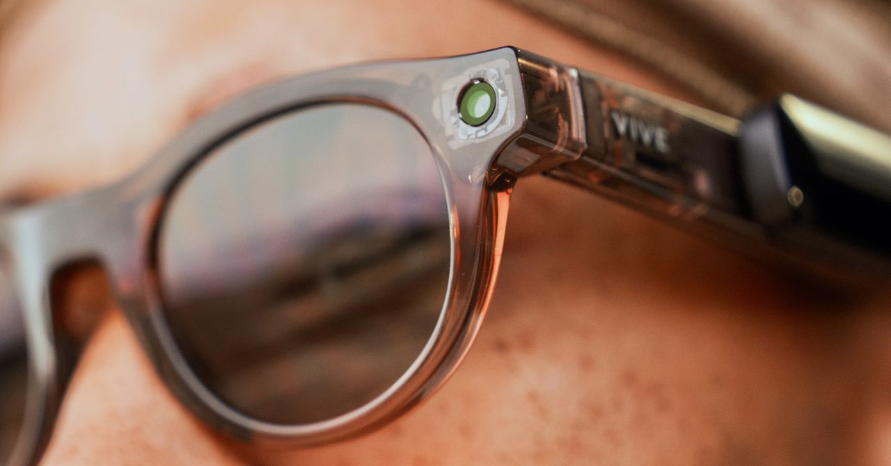 HTC privacy glasses on a desk with a faint holographic cityscape overlay