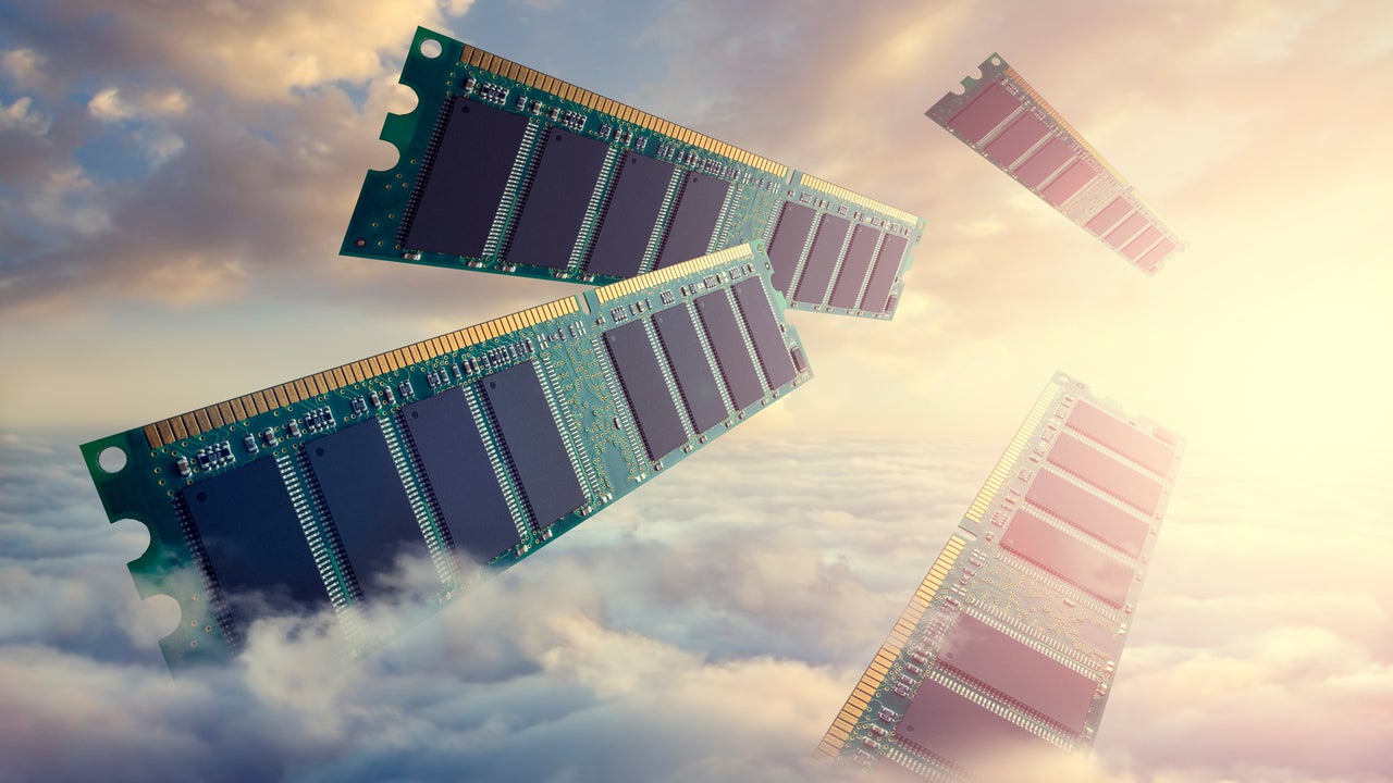 Desk with laptop, desktop, and RAM modules illustrating memory cost concerns